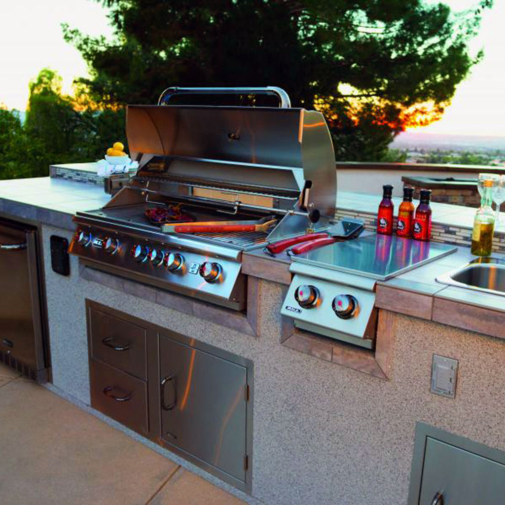 Outdoor kitchen sink with stainless steel basin and faucet on stone countertop