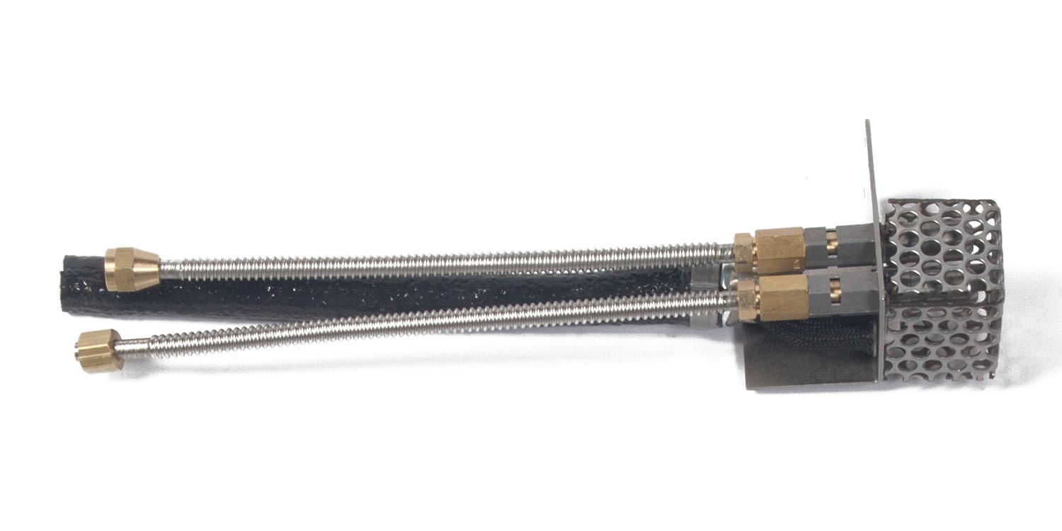 Pilot burner assembly with black perforated end and two brass fittings on metal tube