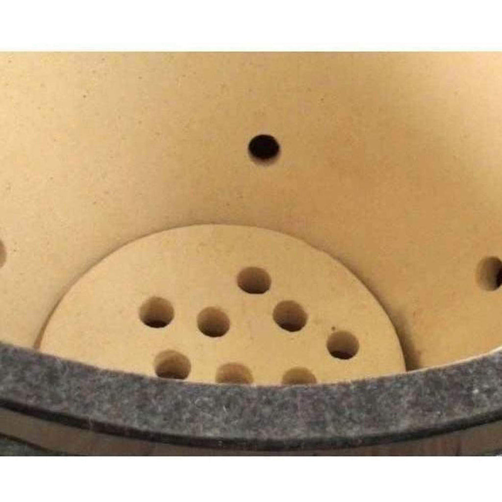 Ceramic firebox with circular air holes and round grate plate.