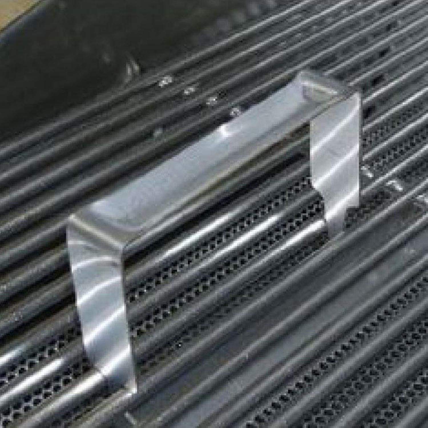 Metal grid lifter tool clipped to grill bars, lifting a grate section