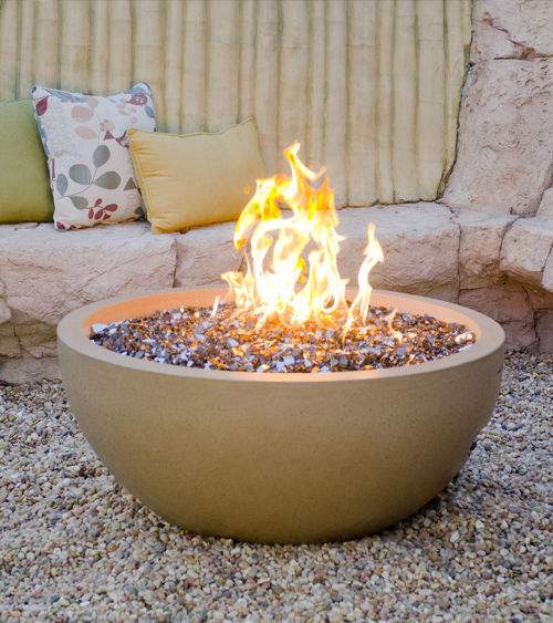 Beige outdoor fire bowl with bright flames and black fire media