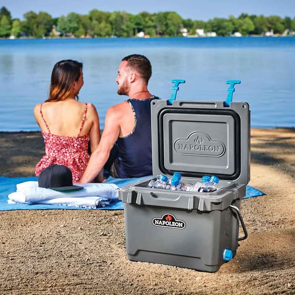Gray cooler chest open with ice and blue-capped bottles, Napoleon logo