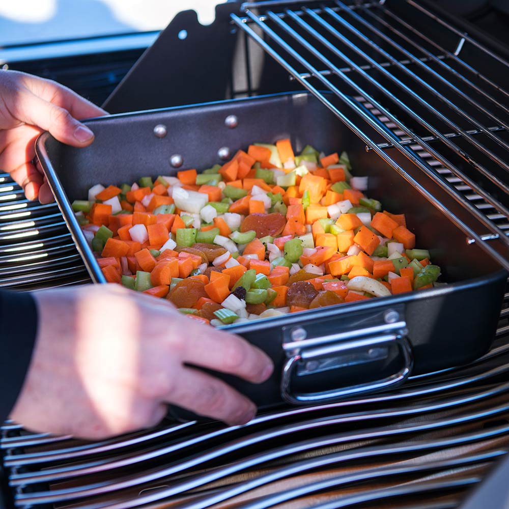 Napoleon Grill roasting pan with diced vegetables being placed on grill rack