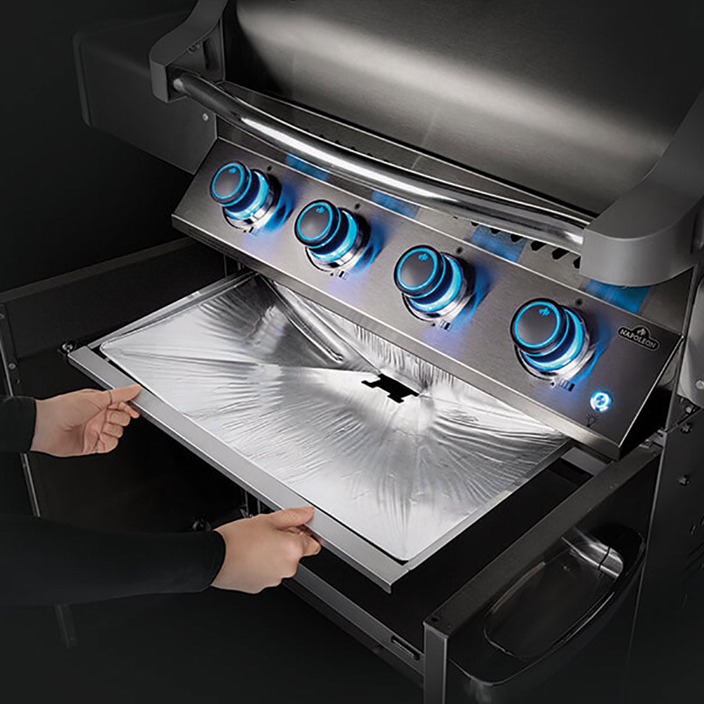Aluminum drip pan liner installed inside a grill beneath the burners