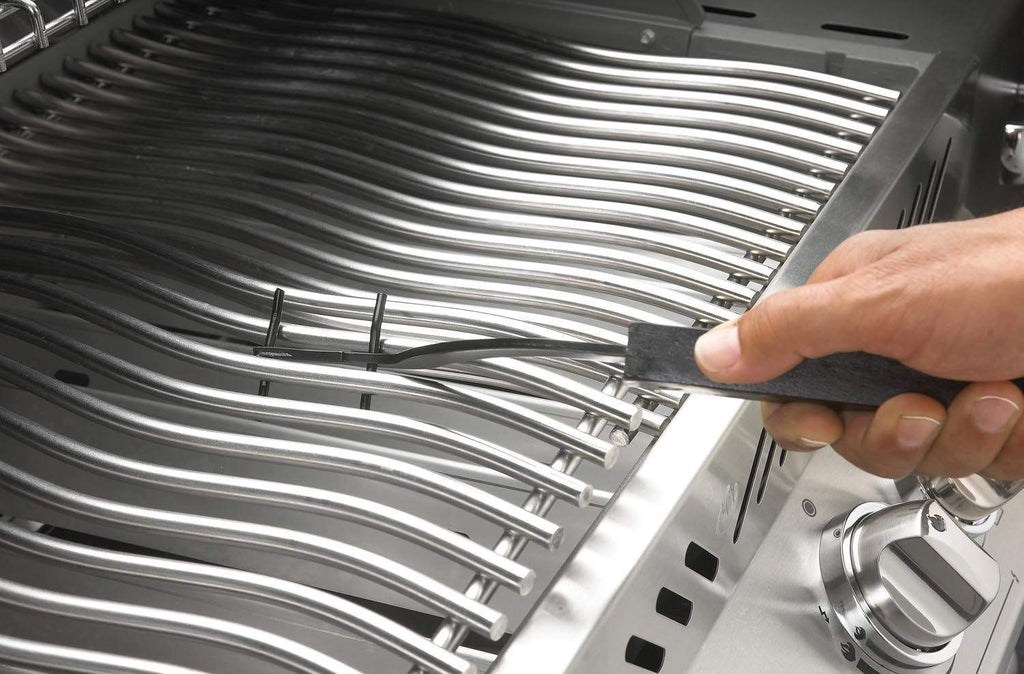Grid lifter being used to lift a metal grill grate, prongs on stainless bars