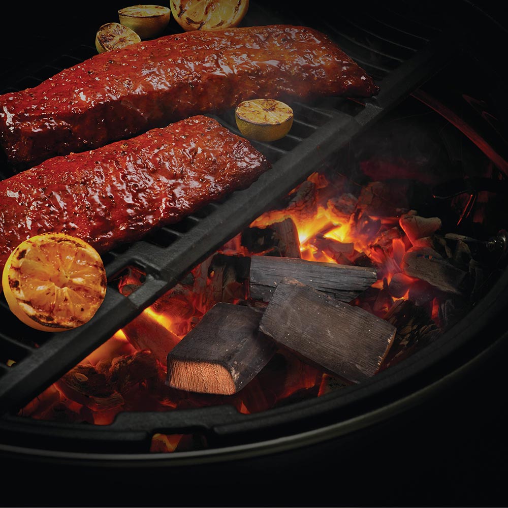 Brandy barrel wood chunks on a grill grate with small flames