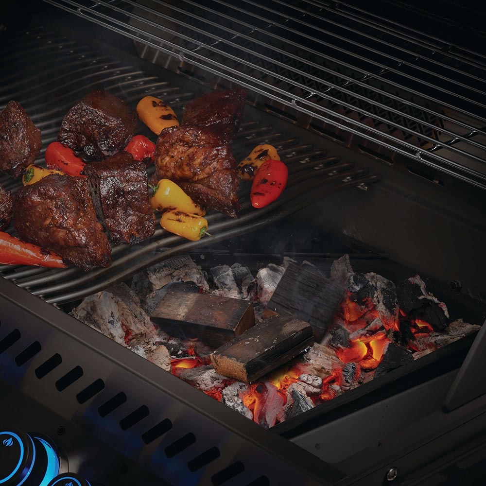 Brandy barrel wood chunks in a grill fire box among lit coals