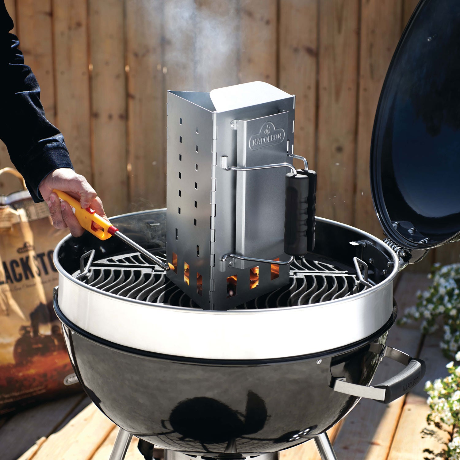 Charcoal chimney on grill, folded metal triangle with black handle attached
