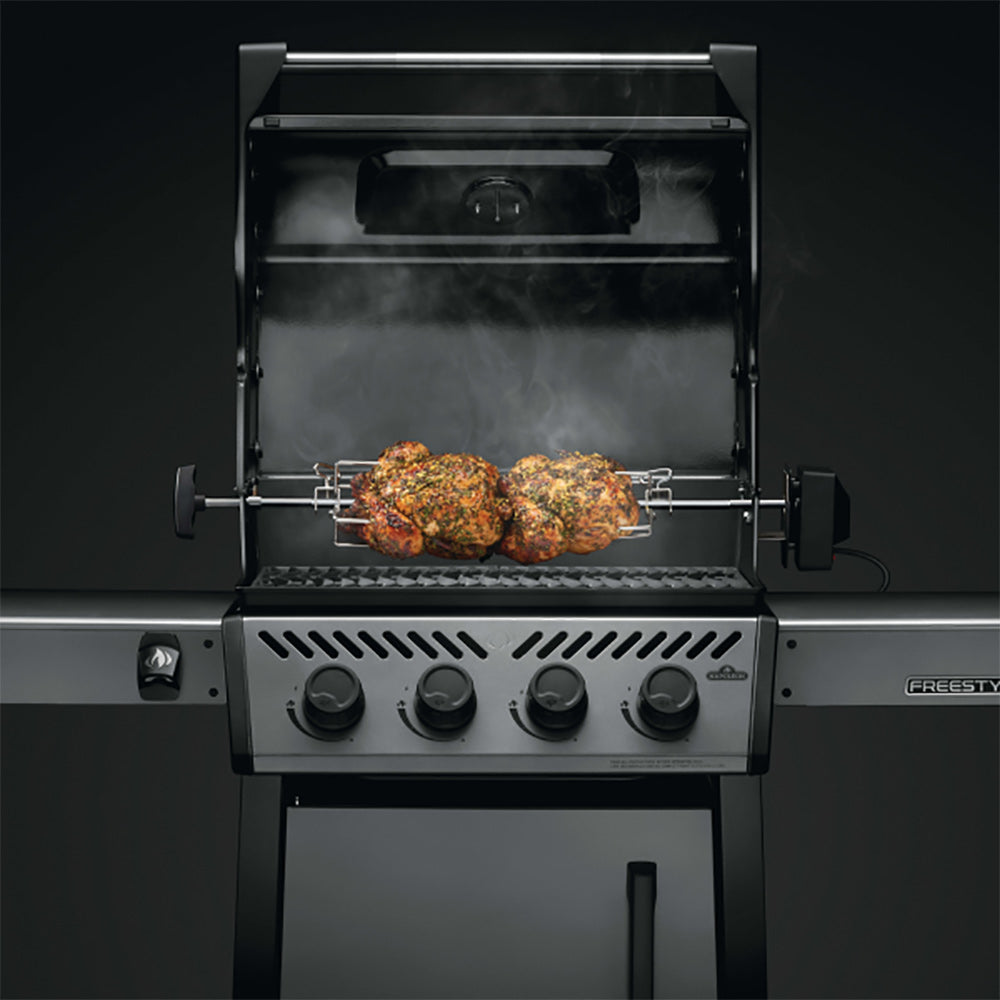 Rotisserie grill with spit holding two roast chickens, motor control on front
