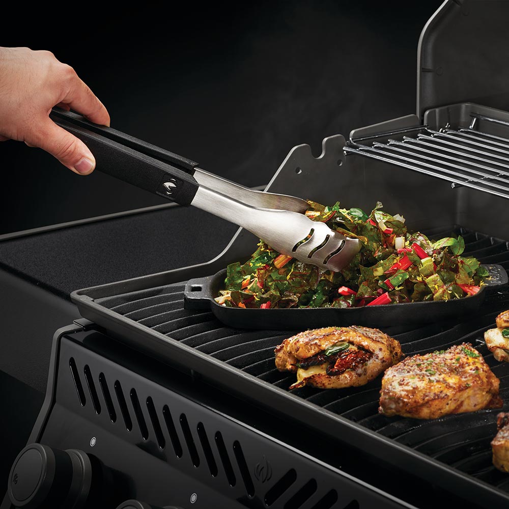 BBQ spatula lifting a serving of grilled vegetables on the grill
