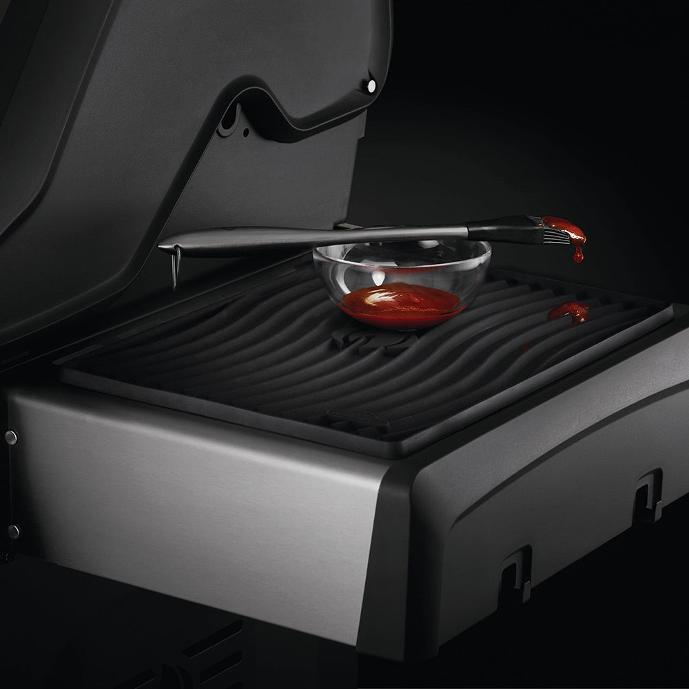 Black silicone side shelf mat with ridged grooves holding utensils and cookware