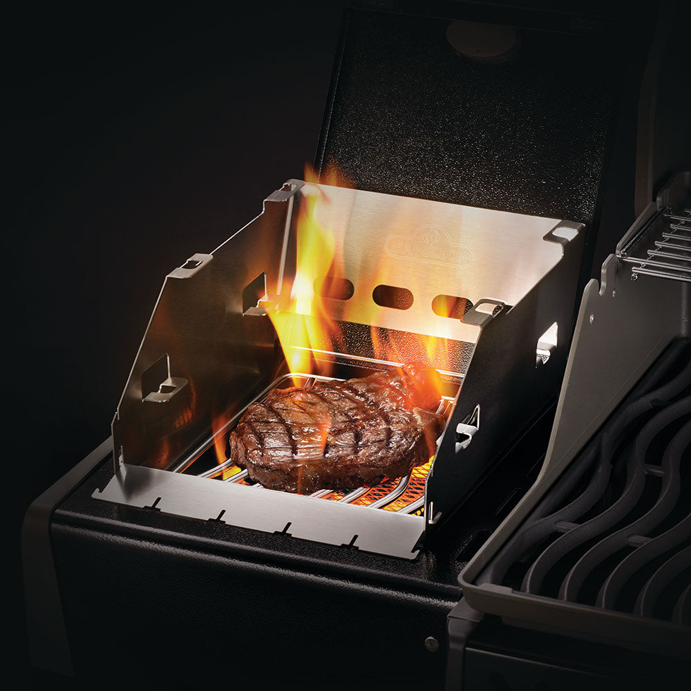 Metal side burner windshield holding a skewer rack over grill flames and meat