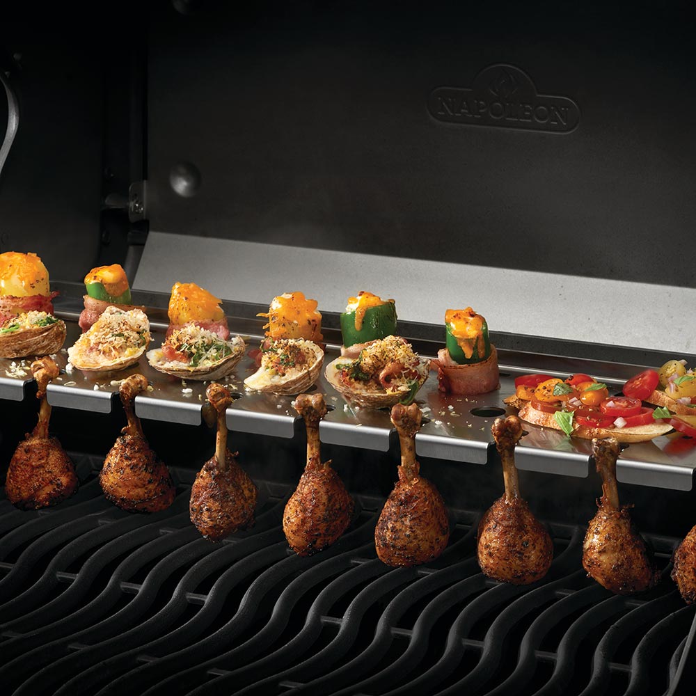 Multifunctional warming rack installed on grill, hooks holding roasted food