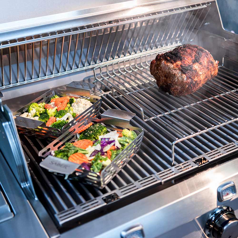 Roasting rack insert with ribbed wire surface holding chicken and vegetables on grill