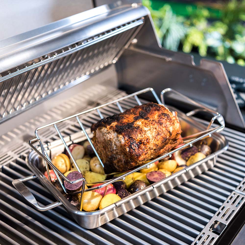 Stainless steel roast rack with seasoned meat and vegetables on grill grates