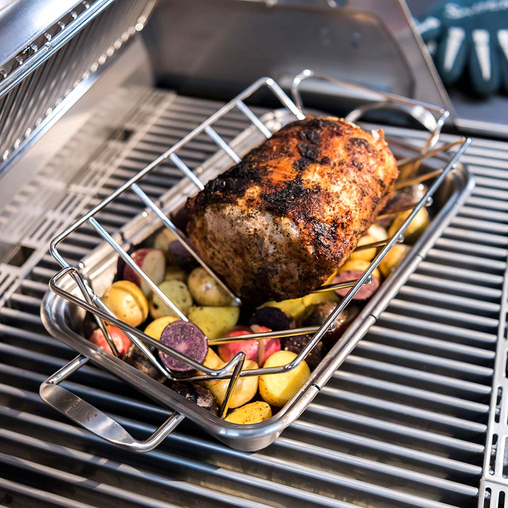 Stainless steel roast rack lifting a large piece of grilled meat over vegetables