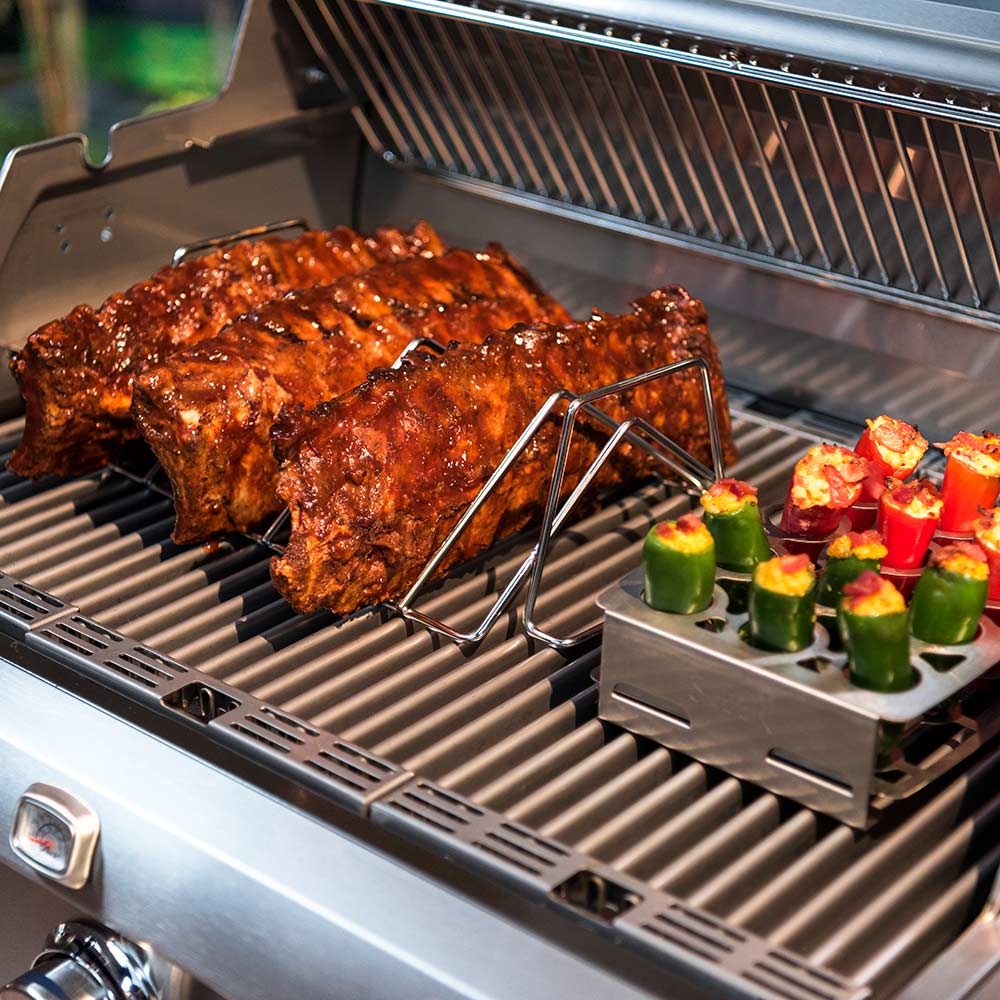 Stainless steel roast rack with a large grilled roast and colorful vegetables on grill