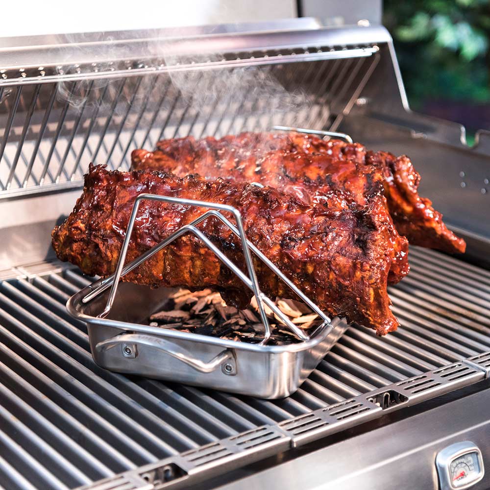 Stainless steel rib rack supporting a seasoned roast on grill grates