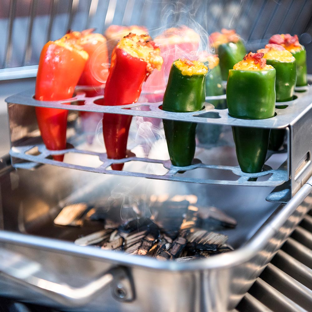 Stainless double pepper roaster rack with stuffed peppers, steam rising on grill