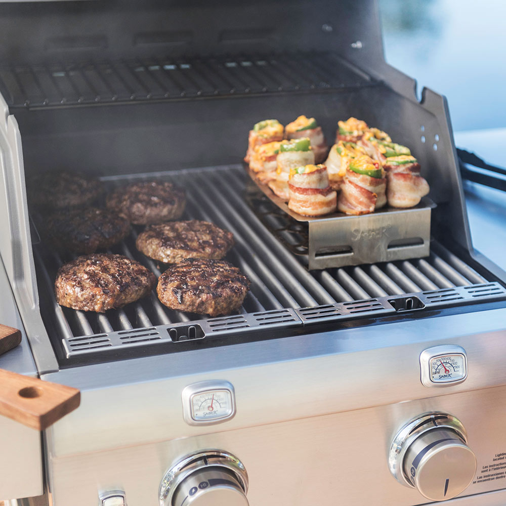 Double pepper roaster on grill grates, holding stuffed peppers on perforated tray