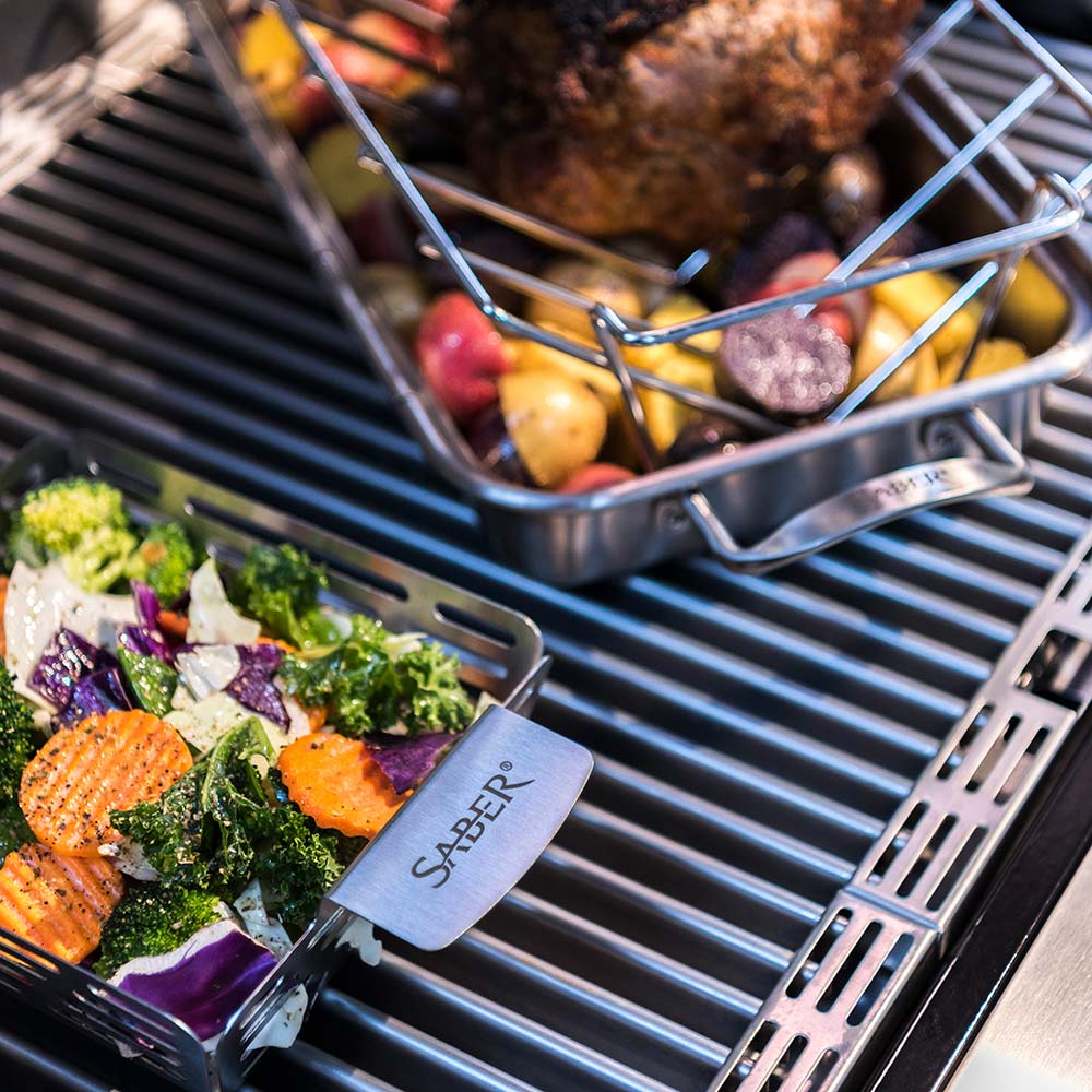 Saber grill grates with cooked vegetables and salmon fillet on stainless surface