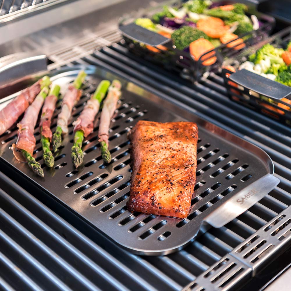 Saber grill basket tray with seasoned salmon steak over ridged cooking grate