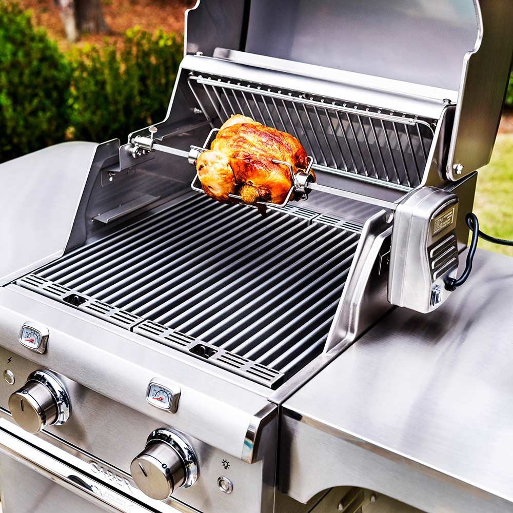 Rotisserie chicken on grill with spit and forks installed on stainless burners