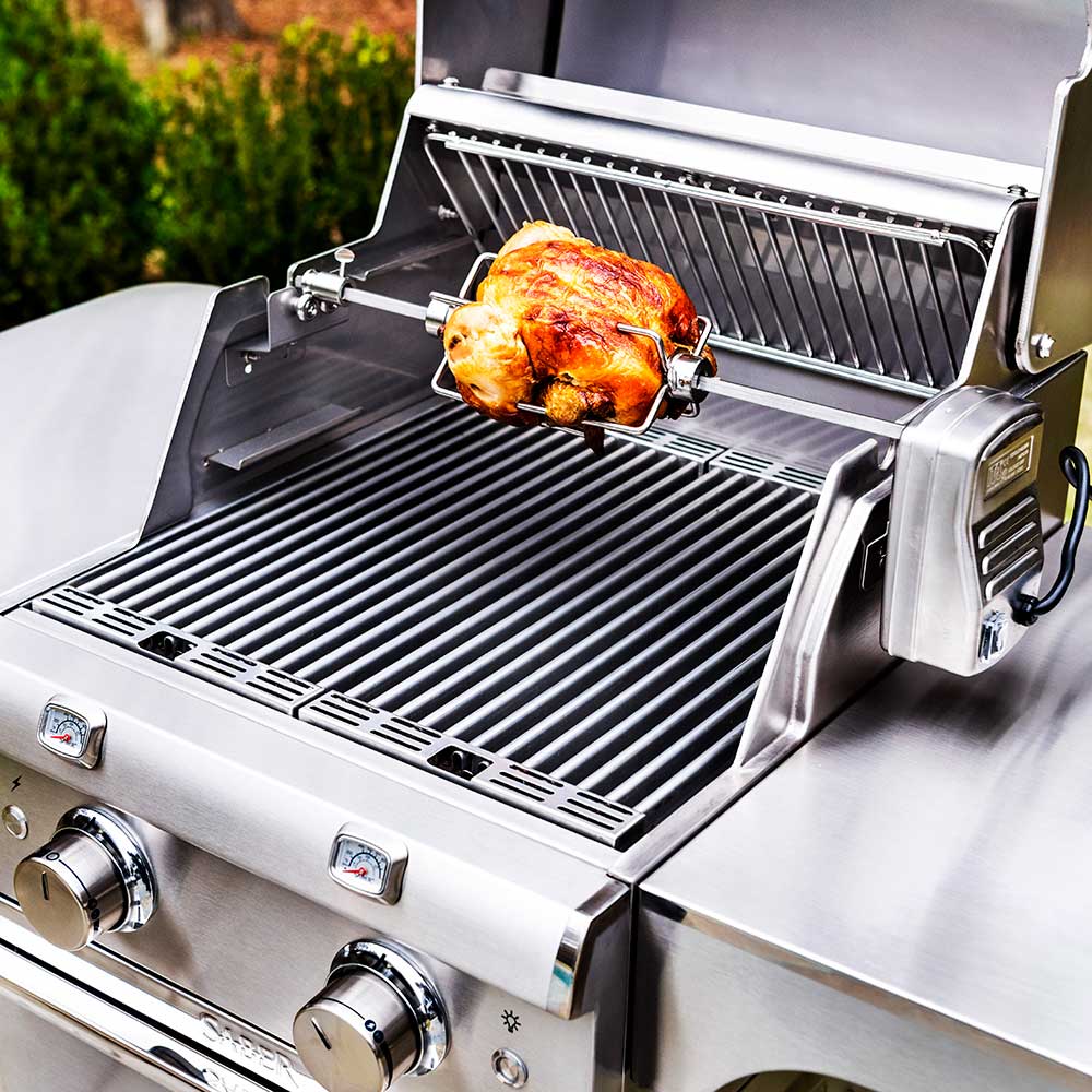 Rotisserie spit rod with whole chicken on grill grates, rotisserie bracket