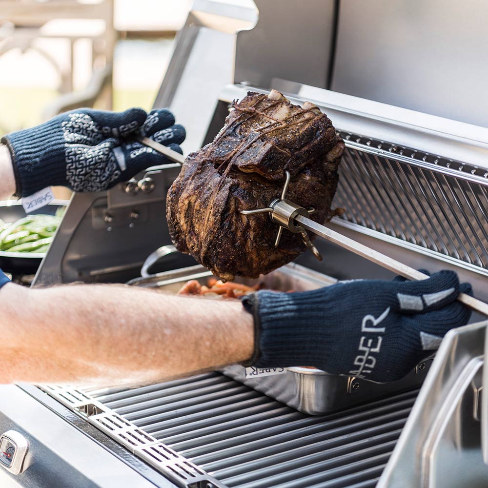 Rotisserie rod with chicken secured on spit over open grill