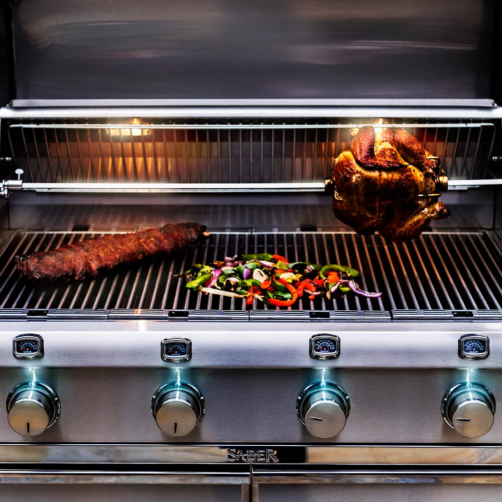Rotisserie spit rod holding whole chicken in barbecue grill