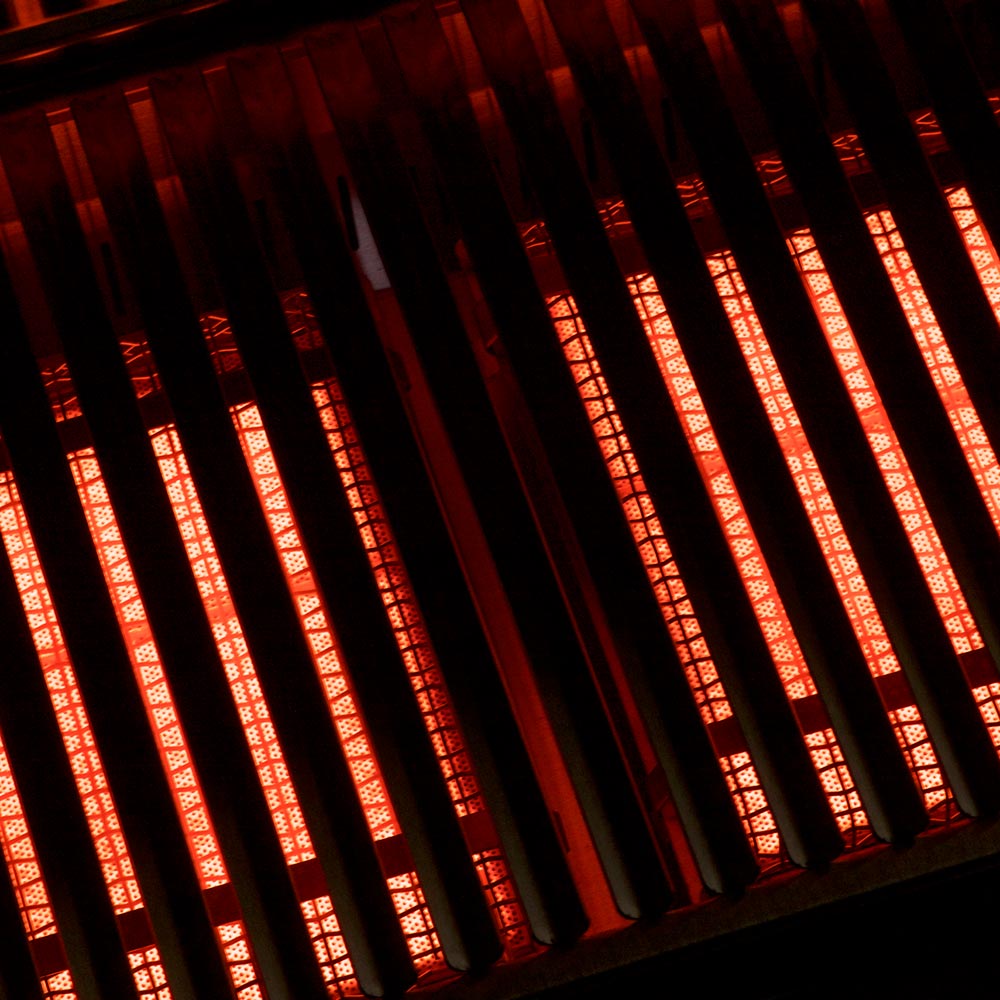 Infrared burner heating elements glowing red inside the grill
