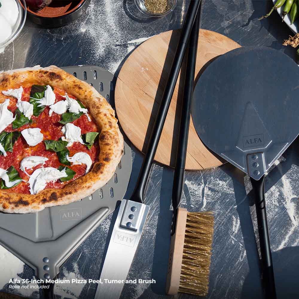Pizza peel set with perforated peel, flat turner, and brush near topped pizza