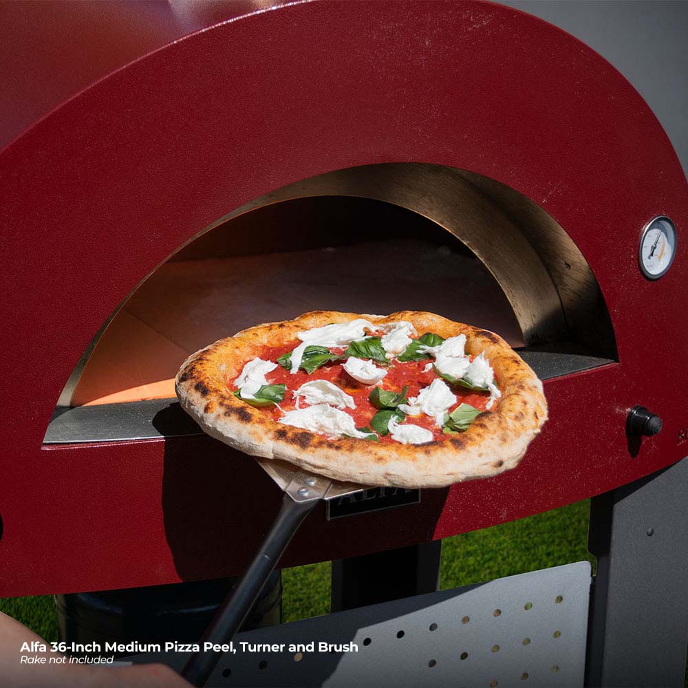 Pizza turner and peel holding topped pizza above a grill grate