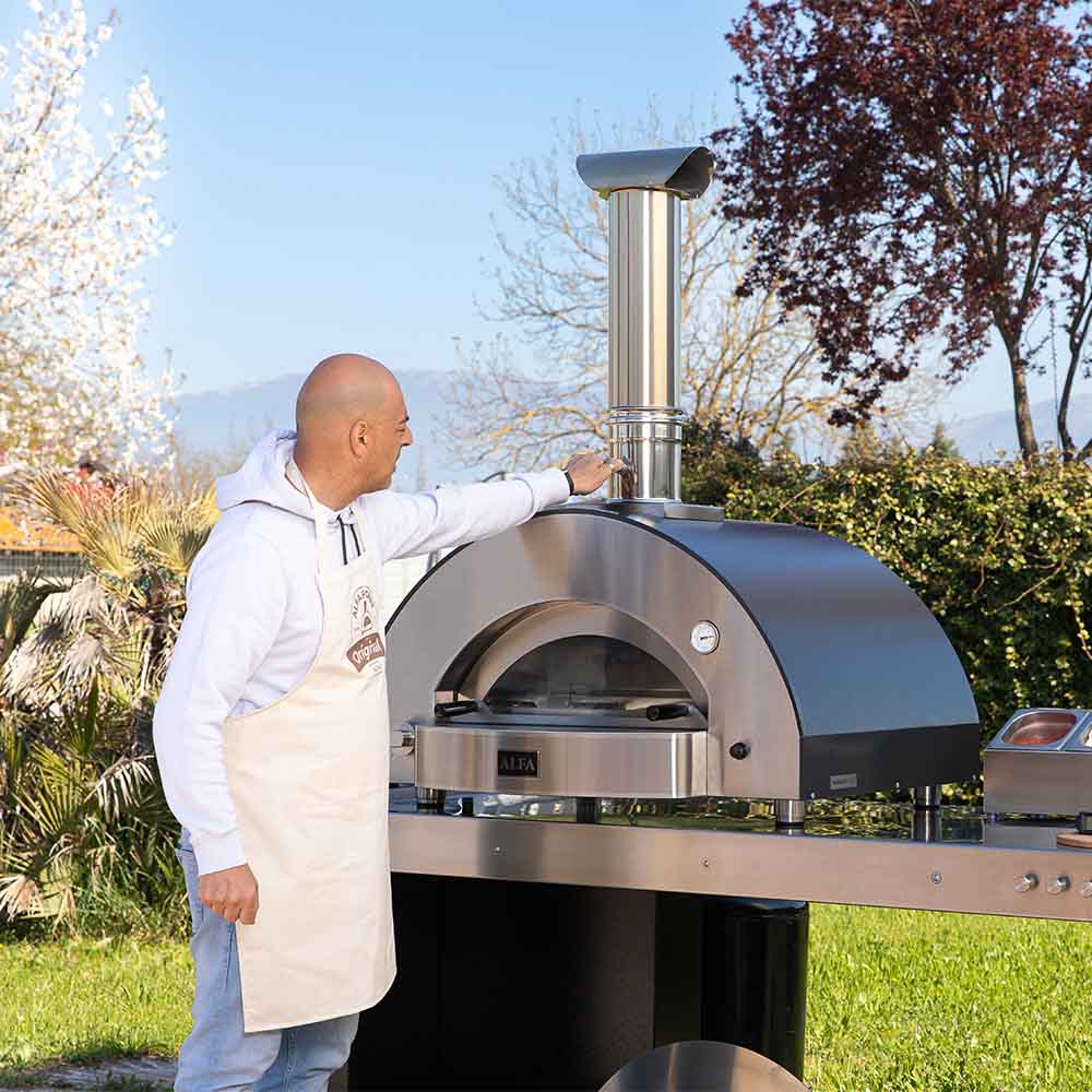 Outdoor pizza oven with chimney flue and domed baking chamber on base