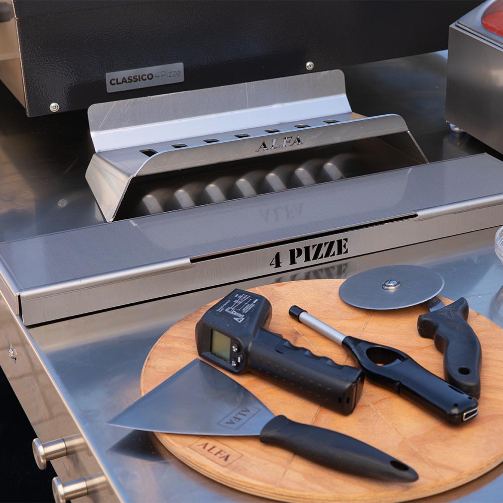 Pizza oven kit inside view with vented metal fire tray and tools on base