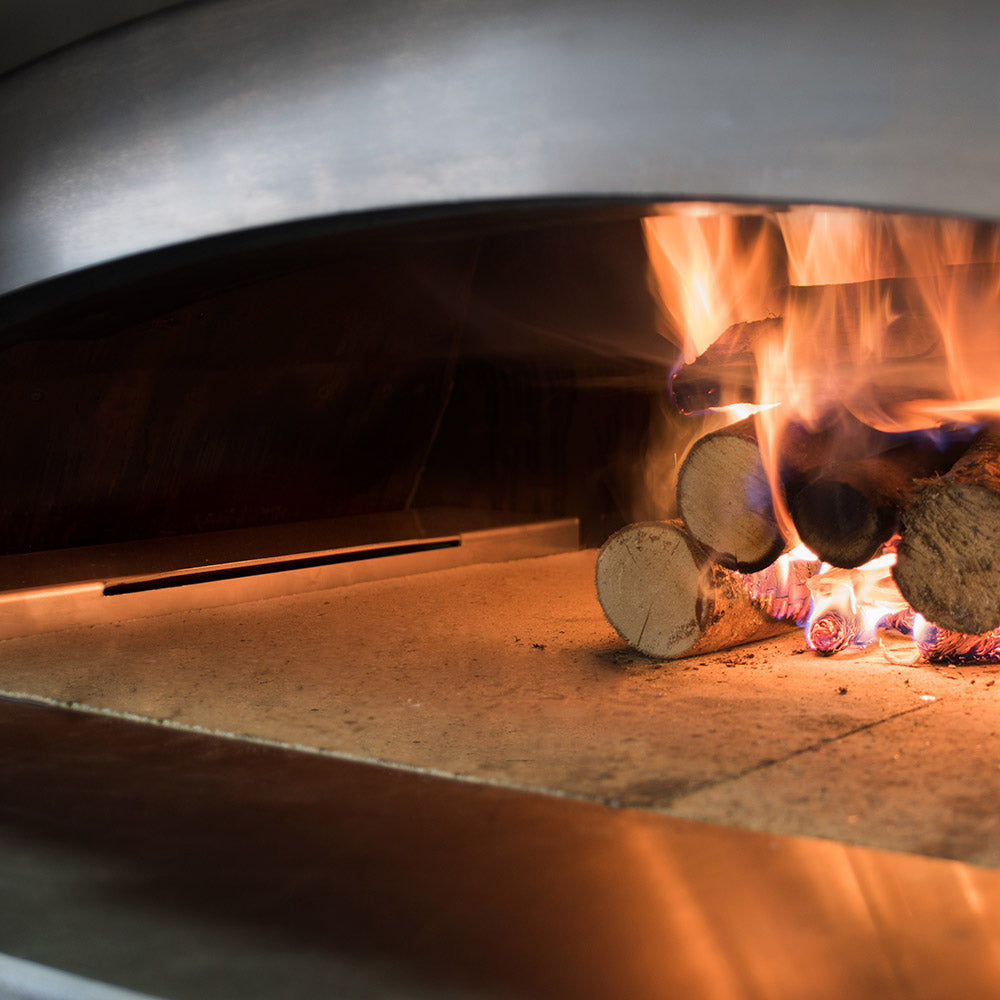 Pizza oven firebox with stone baking floor and long metal support bar