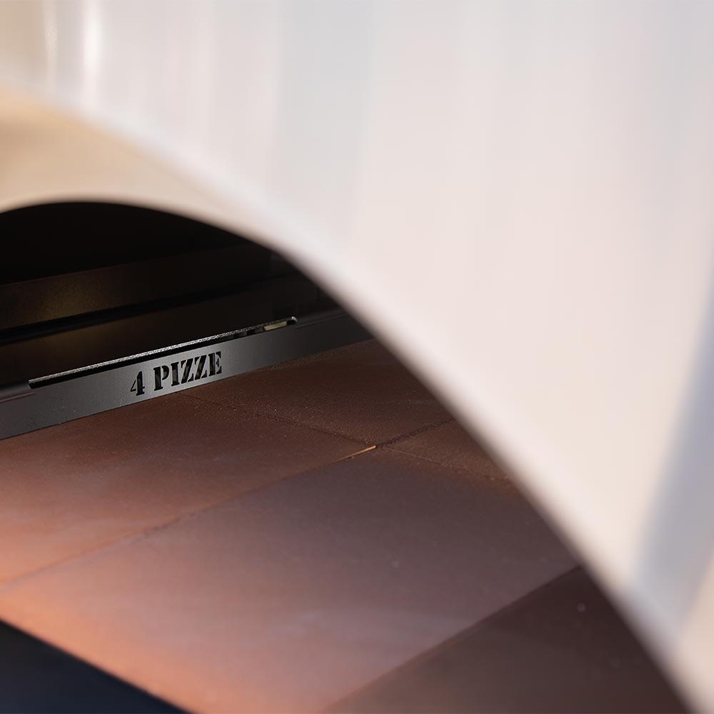 Pizza oven firebox interior viewed through an opening, showing glowing coals and logs