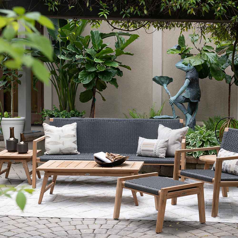 Outdoor patio seating set with dark gray cushions and light wood frames, plus matching side chairs