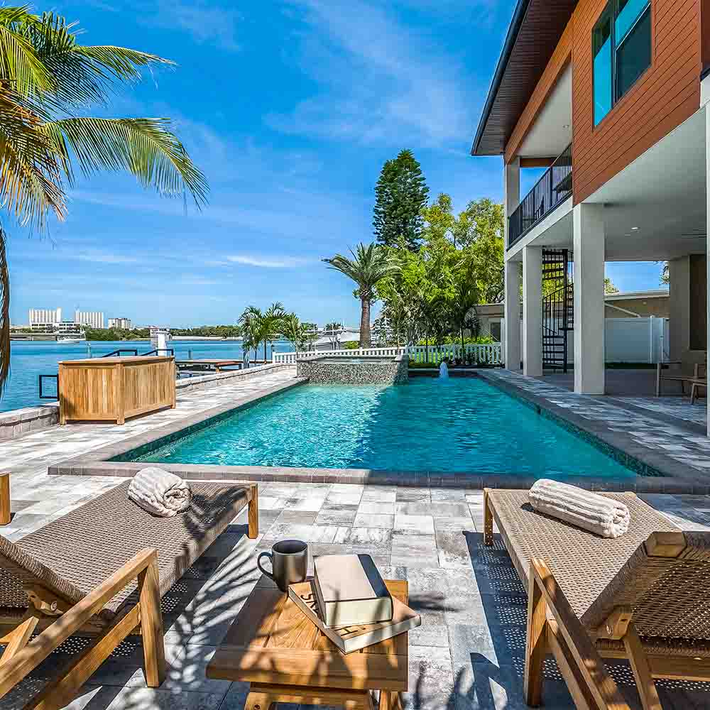 Outdoor lounge set with woven-cushion chairs and a small teak coffee table