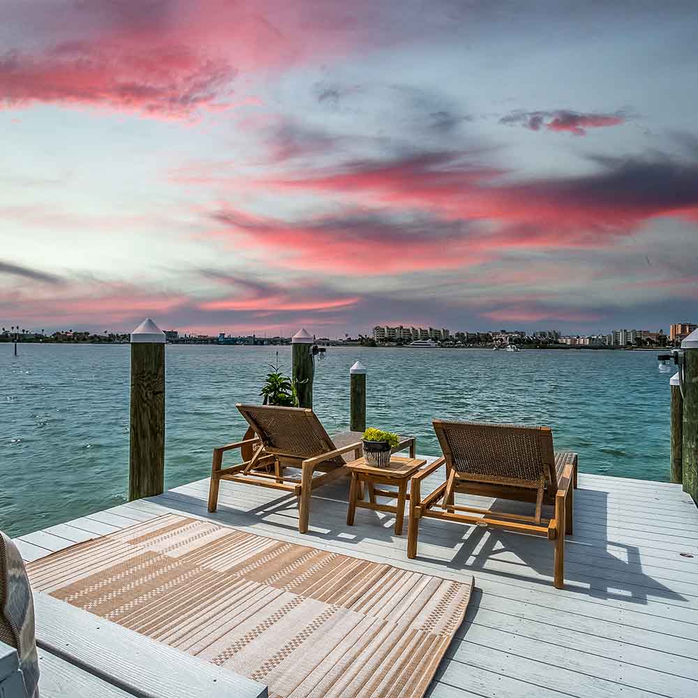 Outdoor lounge set with two loungers and a small teak coffee table on a deck