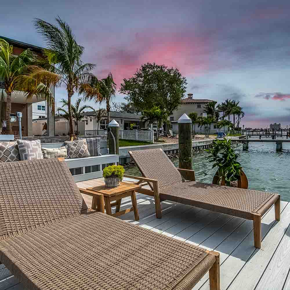 Outdoor lounge set with woven loungers and a small teak side table