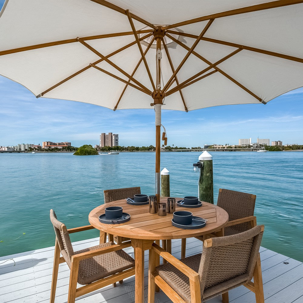Outdoor dining table with woven chairs and cantilever patio umbrella