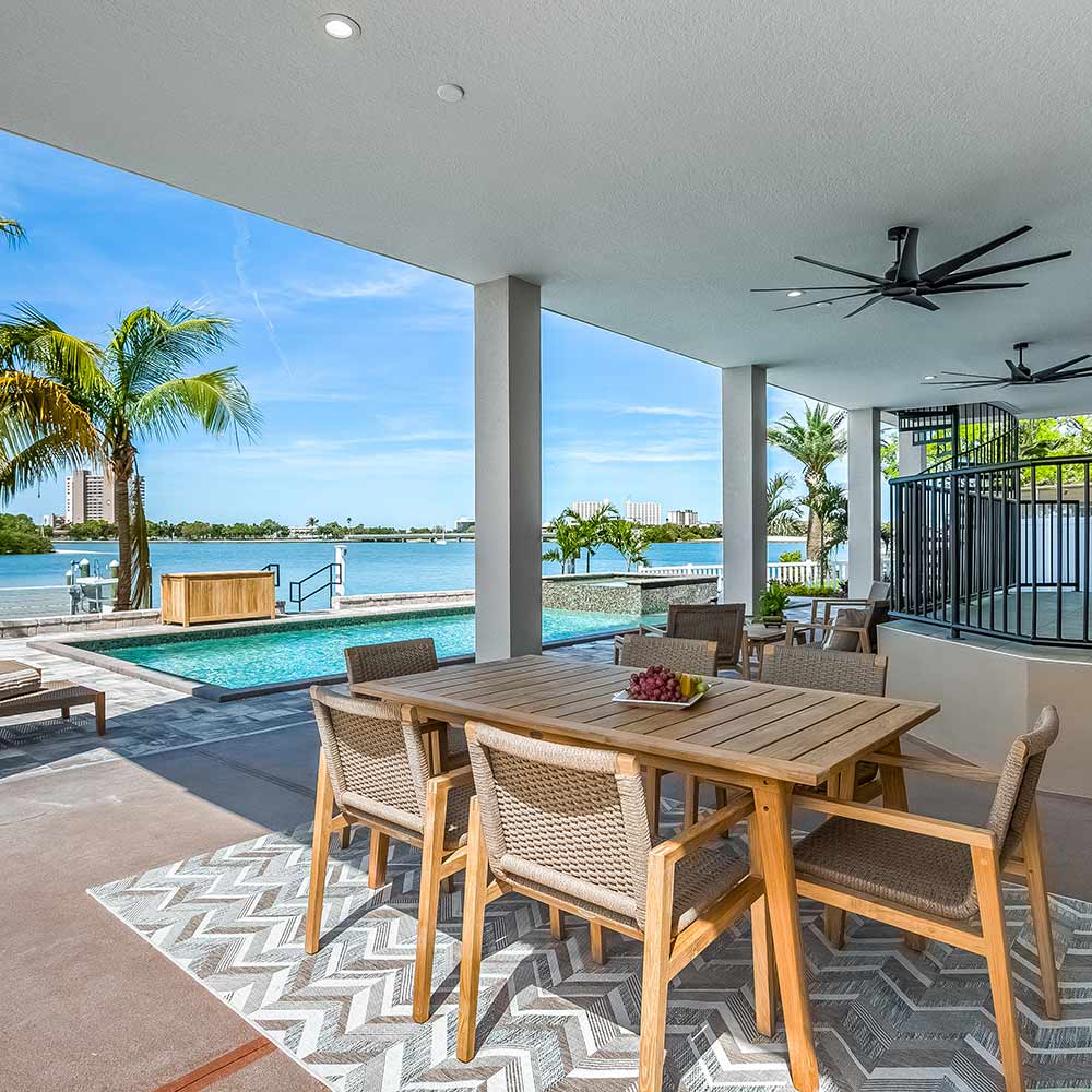 Teak dining table with slatted top and matching chairs on a patio terrace