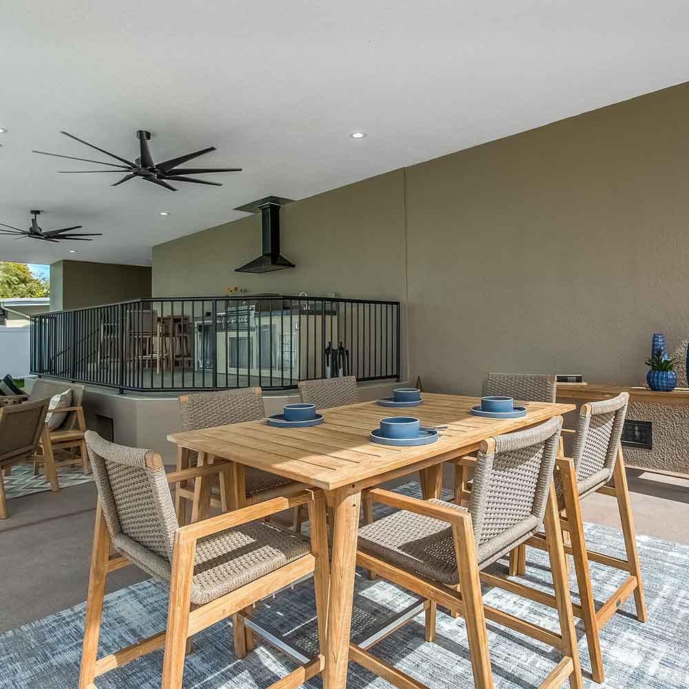 Outdoor dining table set with rectangular teak table and woven chairs with armrests