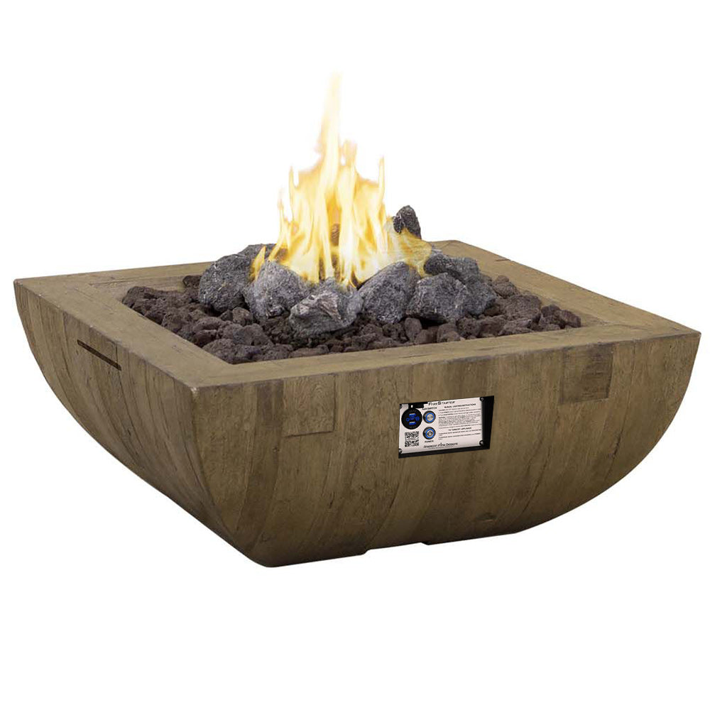 Square gas fire bowl with flame, dark lava rocks, and product label on reclaimed wood.