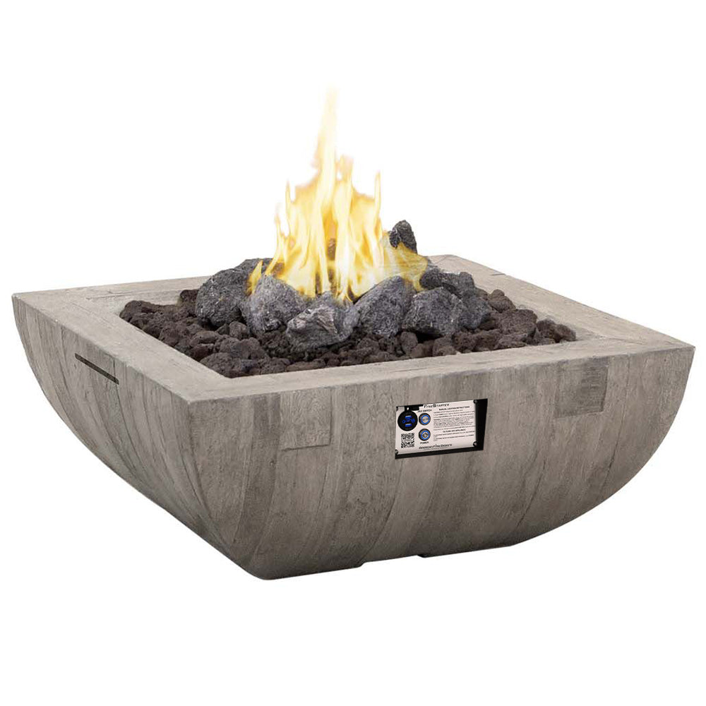 Square gas fire bowl with open flame, dark lava rocks, and identification label on side.