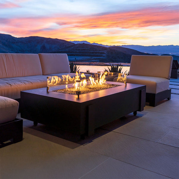 Rectangular gas fire table with dark finish and open firebox, flames burning across the center