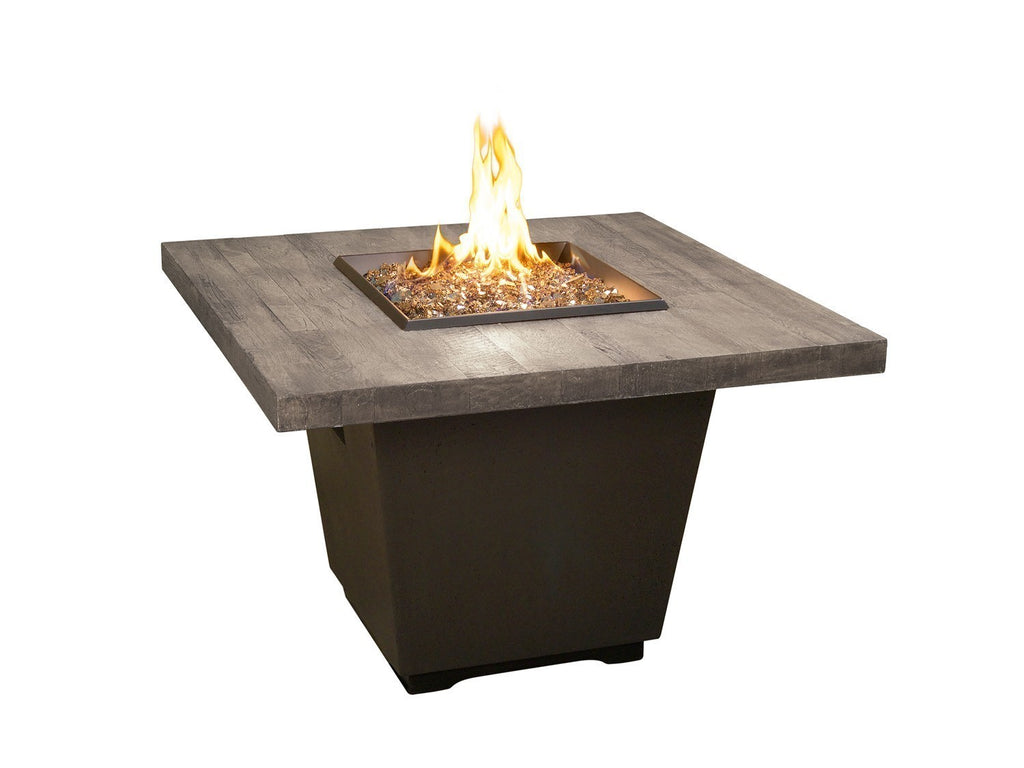 Square fire table with gray reclaimed-wood top, black base, and flame from burner