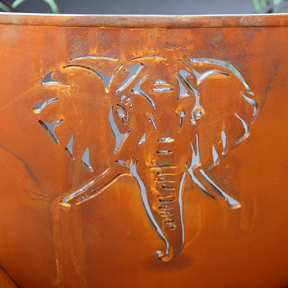 Close-up of orange gas fire pit with raised animal relief design on the bowl.
