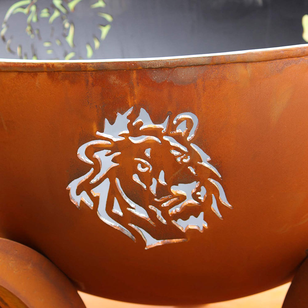 Close-up of orange gas fire pit bowl with raised lion relief detail.